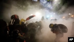 Federal officers launch tear gas at a group of demonstrators during a Black Lives Matter protest at the Mark O. Hatfield United States Courthouse in Portland, Oregon, July 26, 2020. 