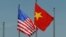 FILE - The U.S. flag flutters next to the Vietnamese flag during a welcoming ceremony for the U.S. defense secretary in Hanoi, Vietnam June 1, 2015. Vietnam has advocated for relaxation of the arms embargo to reflect a greater level of trust with the U.S.