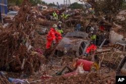 Emergency services remove cars in an area affected by floods in Catarroja, Spain, Nov. 3, 2024.