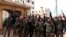 In this photo released Feb. 16, 2020 by the Syrian official news agency SANA, Syrian army soldiers flash the victory sign in the Rashideen neighborhood, in Aleppo province, Syria.