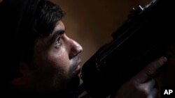 A federal policeman looks towards IS positions during fighting at the front line near the old city, on the western side of Mosul, Iraq, March 29, 2017.