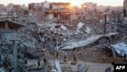 Palestinians walk in a devastated neighborhood due to Israeli strikes in the southern Gaza Strip city of Khan Yunis on Dec. 2, 2024.