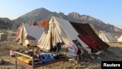 FILE - An Afghan national rests on a cot at a camp after returning from Pakistan at the Torkham border crossing between Pakistan and Afghanistan, November 14, 2023.