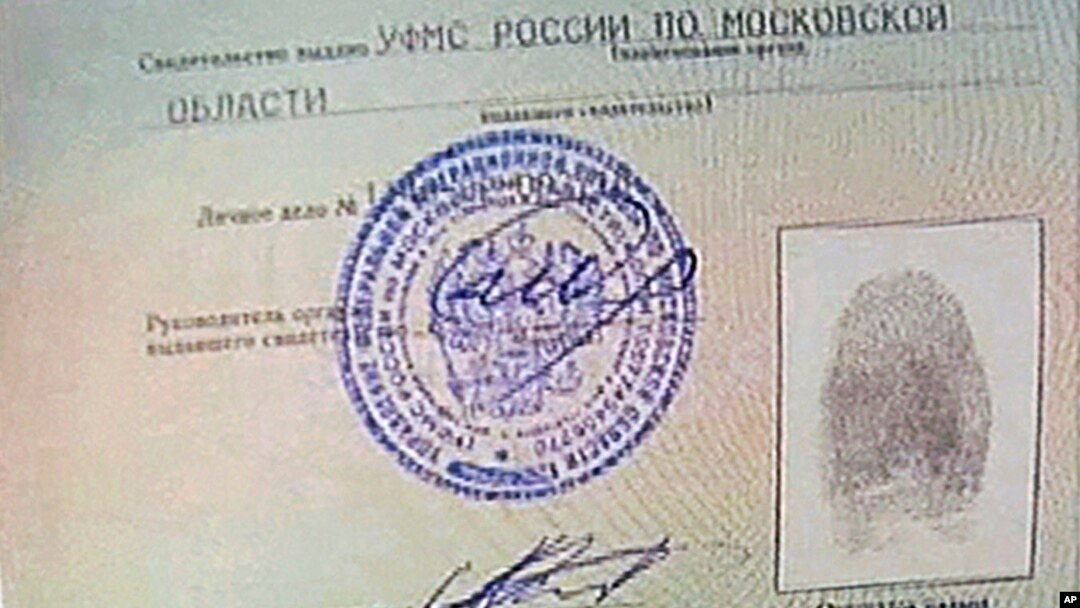 An image taken from AP Television shows a copy of a temporary document that allows Edward Snowden to cross the border into Russia, held by Russian lawyer Anatoly Kucherena visiting Snowden at Sheremetyevo airport outside Moscow, August 1, 2013. 