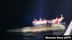 A photograph  released Oct. 19, 2024, by the Mexican Navy shows a semi-submersible vas  suspected of transporting amerciable  narcotics being detained southwest of the larboard  of Lazaro Cardenas, disconnected  the authorities   of Michoacan, Mexico. (Photo from Mexican Navy/AFP)