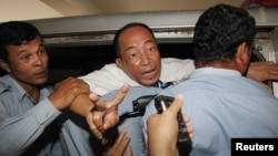 Mam Sonando (C), a 71-year-old radio broadcaster and land-rights campaigner for 20 years, gestures after his verdict at the Phnom Penh Municipal Court, October 1, 2012.