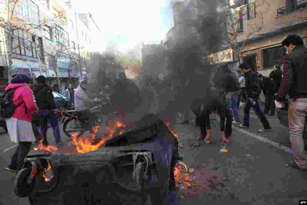 A dumpster burns on a street near Azadi Square in Tehran