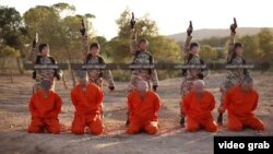 FILE - A screenshot from an Islamic State propaganda video purports to show young boys executing a group of captives.