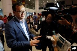 FILE - Cambodia's exiled opposition leader Sam Rainsy, left, speaks to the media at Kuala Lumpur International's Airport in Sepang, Malaysia, Nov. 9, 2019.