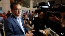 Cambodia's exiled opposition leader Sam Rainsy, left, speaks to the media as he arrived at Kuala Lumpur International's Airport in Sepang, Malaysia, Nov. 9, 2019. Sam Rainsy is trying to return to his homeland after Thailand blocked him from entering.