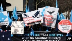 FILE - Uighurs and their supporters rally across the street from the United Nations headquarters in New York, March 15, 2018.