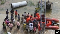 National Disaster Response Force (NDRF) personnel rescue people from floodwaters after heavy rainfall in Hyderabad, India, India, Wednesday, Oct. 14, 2020. Record rains and heavy flooding in the southern Indian state of Telangana collapsed houses…