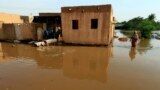 FILE: Residents walk through floodwaters from the Blue Nile as it submerges their neighborhood in the Al-Ikmayr area of Omdurman in Khartoum, Sudan Taken 8.27.2020