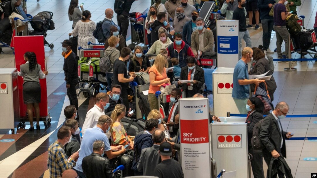 FILE- People lineup to get on the Air France flight to Paris at OR Tambo's airport in Johannesburg, South Africa. 