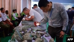 FILE - Buyers checks jade stones before the auction during the annual Myanmar Jade, Gems and Pearl Emporium in Naypyidaw, Sept. 16, 2019. The U.S. has imposed sanctions on Myanma Gems Enterprise (MGE) on April 8, 2021.