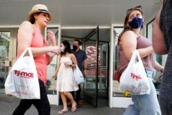 FILE - Shoppers exit a retail store in downtown Chicago, May 22, 2021. As consumption in the U.S. rises, other countries can expect to see that reflected in greater demand for exports.