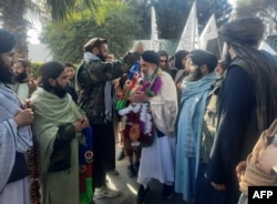 Taliban menyambut pejuang Afghanistan Khan Mohammad (tengah) yang dipenjara di Amerika, saat ia tiba di Jalalabad pada 21 Januari 2025. (Foto: AFP)