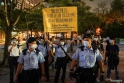 Los agentes de policía dispersan a las personas que lloran en el Parque Victoria en el 32º aniversario de la represión de los manifestantes a favor de la democracia en Tiana de Beijing nmen Square en 1989, en Hong Kong, China, 4 de junio de 2021.