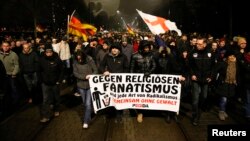 Participants take part in a demonstration called by anti-immigration group PEGIDA, a German abbreviation for "Patriotic Europeans against the Islamization of the West", in Dresden, Jan. 5, 2015. The text reads: 'Against religious fanatism and any kind of radicalism. Together against violence.' 