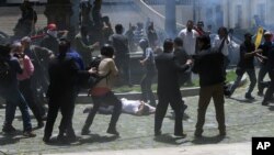 Opposition lawmaker Armando Armas lies on the ground covering his head as pro-government militias attack lawmakers and National Assembly employees, in Caracas, July 5, 2017. 