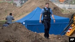 A police officer in Frankfurt, Germany, passes a blue tent that was set up over a 1.8-metric ton bomb of a type dropped by British bombers during World War II, Aug. 30, 2017. City authorities in Frankfurt plan to evacuate more than 60,000 people from their homes on Sunday to defuse the bomb, which was found during construction work this week.