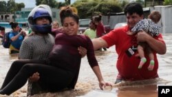 Muškarac nosi trudnicu u potopljoj oblasti nakon prolastka uragana Eta, u Planeti, Honduras, 5. novembra 2020.