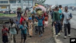 Warga yang melarikan diri dari rumahnya masing-masing akibat pertempuran yang berlangsung di Kongo, berjalan menuju pusat Kota Goma, Republik Demokratik Kongo, pada 26 Januari 2025. (Foto: AP/Moses Sawasawa)