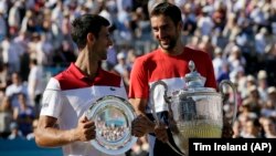 Đoković i Čilić sa trofejima posle današnjeg meča u Londonu (Foto: AP/Tim Ireland)