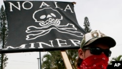 Un manifestante sostiene un cartel durante una protesta contra operaciones mineras de oro y plata de Canadá frente al consulado canadiense en San Salvador en 2007.