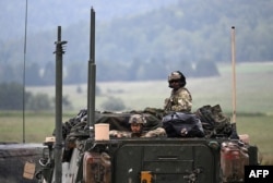 US soldiers of an artillery unit stand in a personnel army vehicle during the NATO exercise 'Saber Junction 23' at the Hohenfels trainings area, southern Germany, on September 14, 2023.