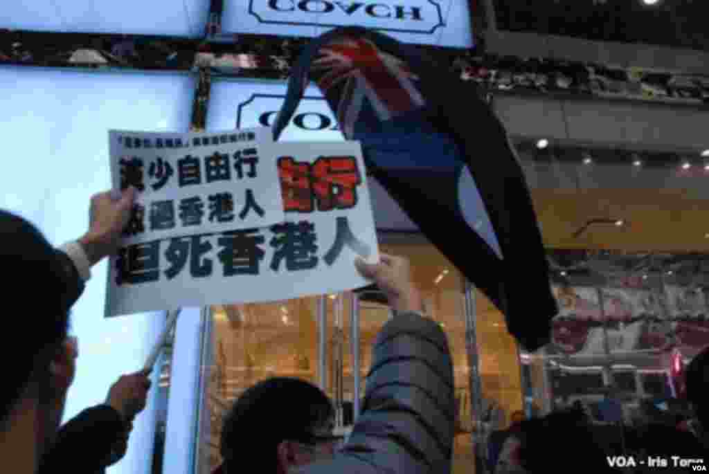 Protesters chase mainland visitors into a luxury retail store, which closes its doors to protect the mainlanders. (Iris Tong, VOA)