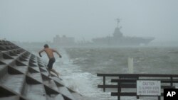 A man jumps from a wave as Hurricane Hanna begins to make landfall, July 25, 2020, in Corpus Christi, Texas. 