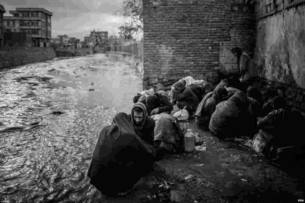 Drug users at a riverbank in Kabul. (Maciej Stanik/VOA)