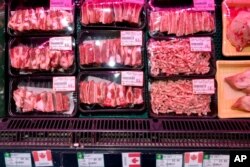 FILE - Packs of Canadian pork are displayed for sale at a supermarket in Beijing, June 18, 2019.