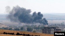 Asap mengepul akibat pertempuran di kota Kobani, terlihat dari Mursitpinar dekat kota Suruc, perbatasan Turki dengan Suriah (6/10).