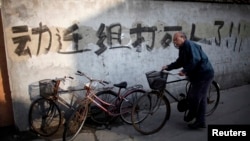 一名男子騎車走過上海街頭一處拆遷地（2010年12月1日）