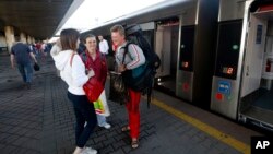 Ukrainians gather next to a train bound for Poland's Przemysl from the central railway terminal in Kyiv, Ukraine, June 11, 2017. 