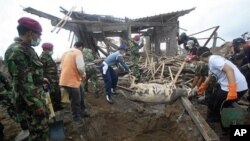 Indonesian marines and volunteers bury carcass of cow killed in Mount Merapi eruption in Kinahrejo village, Yogyakarta, Indonesia, 28 Oct. 2010.