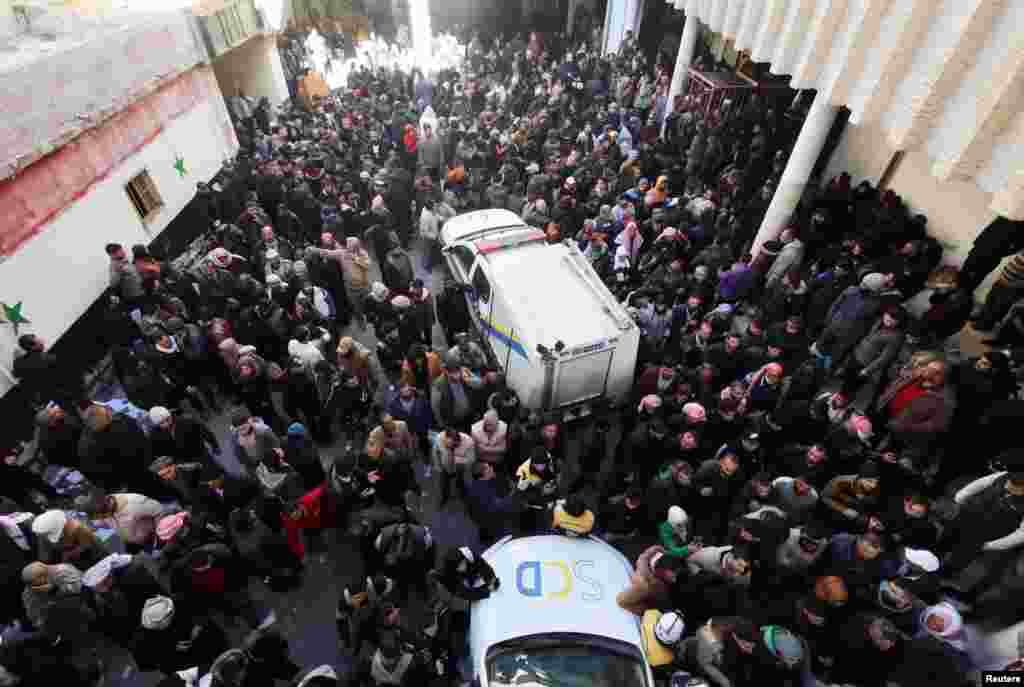 People gather as members of the Syrian civil defense group, known as the White Helmets, search for prisoners underground at Sednaya prison in Sednaya, Dec. 9, 2024.