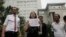 Li Wenzu, center, wife of imprisoned lawyer Wang Quanzhang, holds a paper that reads "Release Liu Ermin" as she and supporters of a prominent Chinese human rights lawyer and activists stage a protest outside the Tianjin No. 2 Intermediate People's Court in Tianjin, China on Aug. 1, 2016.