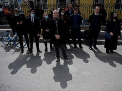 FILE - Diplomats from various countries wait outside of the Dandong Intermediate People's Court, where the trial of Canadian businessman Michael Spavor is being held, in Dandong in China's northeast Liaoning province, March 19, 2021.