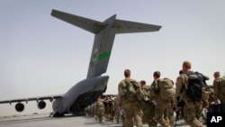 FILE - U.S. soldiers load onto a U.S. military plane as they leave Afghanistan, at the U.S. base in Bagram, north of Kabul, Afghanistan, July 14, 2011. 