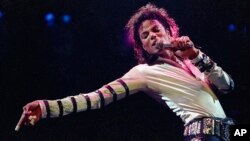 FILE - Michael Jackson leans, points and sings, dances and struts during the opening performance of his 13-city U.S. tour, in Kansas City, Missouri. 