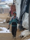 Palestinsko dijete bježi da se skloni od kiše u kamp, 20. decembra 2024. godine. (Foto: Eyad BABA/AFP