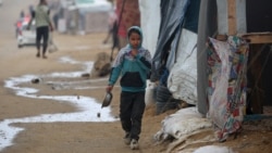 Palestinsko dijete bježi da se skloni od kiše u kamp, 20. decembra 2024. godine. (Foto: Eyad BABA/AFP