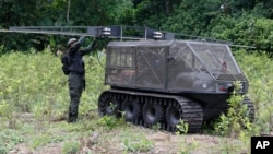 A police officer calibrates the sprinklers on a tactical vehicle used to spray herbicides before testing it on a coca field in Tumaco, southern Colombia, April, 18, 2018. Colombia's president on June 26, 2018, approved the use of drones for spraying coca leaves with a herbicide.