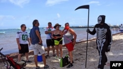 A young man disguised as the death walks at the beach of Puerto Morelos inviting tourists and locals to return to their homes -as the beaches are still closed to visitors- in Puerto Morelos, state of Quintana Roo, on August 1, 2020 amid the COVID-19…