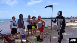 A man disguised as Death walks at the beach of Puerto Morelos inviting tourists and locals to return to their homes -- as the beaches are still closed to visitors -- in Puerto Morelos, Mexico, on Aug. 1, 2020.