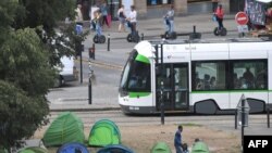 Ilustrasi - Sebuah trem melewati kamp tenda migran di taman umum di pusat kota Nantes, Prancis barat, 30 Agustus 2018. (AFP / LOIC VENANCE)
