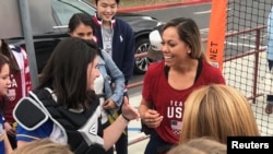 Student Hannah August, left, shares a laugh with U.S. National Softball Team catcher Sahvanna Jaquish, during a visit to Agoura High School, in Agoura Hills, California, Dec. 17, 2018. 